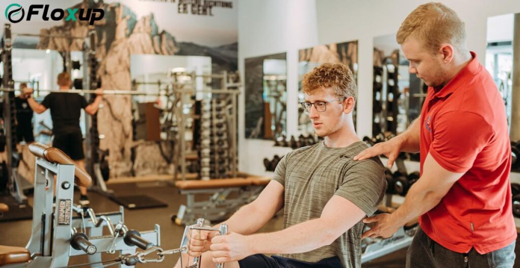 Personal trainer guiding a gym member through a seated row exercise, illustrating the success of partnership marketing for fitness studios.